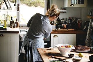 A woman cooking in her kitchen.