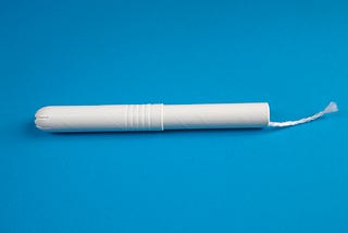 A tampon on a blue backboard.