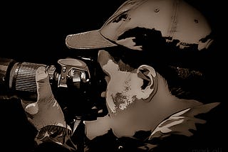 Monochrome (sepia) image of a photographer holding a camera to his eye