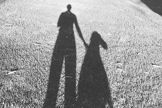 A black and white photo of the author’s shadow along with her dog’s shadow.