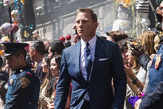 Daniel Craig as James Bond walks through a crowd from the movie set of 007: Spectre.