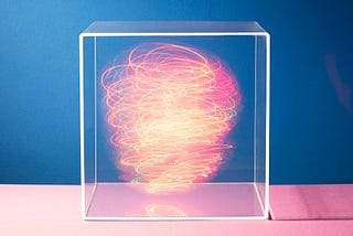 Colorful lights swirling around inside a clear box.