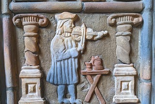 Tile depicting man playing a violin from Moravian Pottery & Tile Works Museum