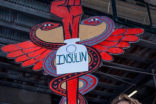 Participant holding a protest sign at a rally for affordable insulin for people with diabetes.