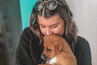 A photo of the author’s wife hugging their new puppy.