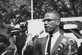 Malcolm X giving a speech at a rally.