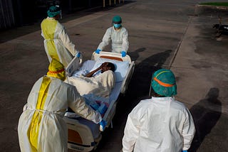 Healthcare workers push a patient into a less intensive unit from the Covid-19 Unit at Houston United Memorial Medical Center