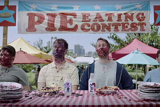 Hint Water Super Bowl commercial shows two men after a pie eating contest with pie over their faces and 2 hint water bottles.
