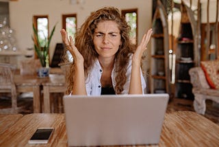Woman looking frustrated at her laptop screen