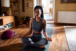 Close up of a young woman meditating at home.