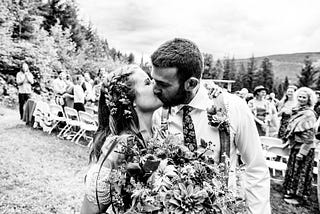 A black and white photo of the author kissing her husband on their wedding day.