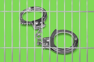 A set of Silver handcuffs behind bars on a bright lime green back ground