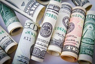 Lori Quayle writes that we need lotteries, accompanied by a picture of rolled dollar bills of various denominations.