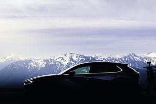 My Mazda sits in front of a row of beautiful mountains on the Olympic Peninsula, a blue sky perfect day.