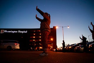 Members from the Lighthouse Fellowship Church gather on a Sunday night outside the Bloomington Hospital to pray for doctors,