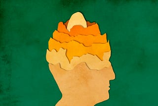 Paper-cut image of layers of a man’s head, with egg at the core.
