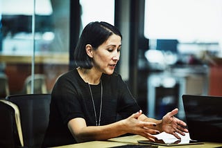 A photo of a woman in a work meeting.