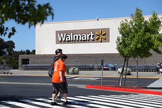 Pedestrians walk by a Walmart store.