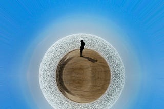 A photo of a man standing in a sphere desert.