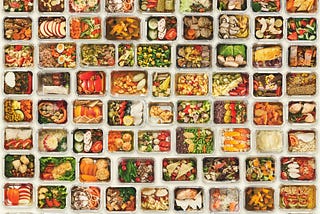 A set of a variety of healthy foods in take away food boxes against a white background.