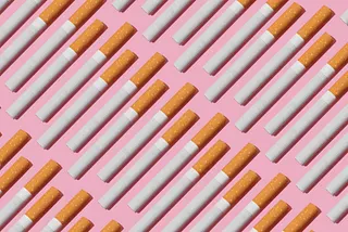 Many cigarettes lined up against pink background.