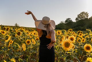 Woman posing joyously in a field of sunflowers