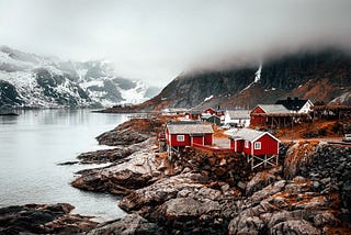Grupo de cabañas a orillas de un lago, típico paisaje noruego.