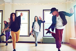 A group of young people dancing together in a studio