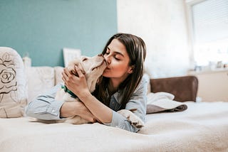 Young woman snuggling with her dog.