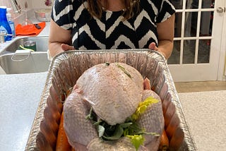 Photo of author Amber Hope and a very large turkey, taken by her mother as part of their 2025 double-down on guilt campaign