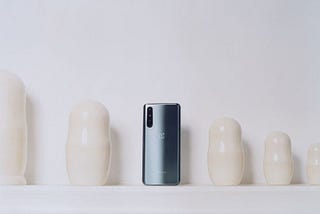A promotional photo of a OnePlus Nord phone against a wall with cream-colored ceramics.