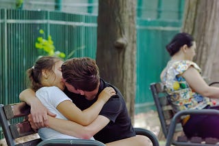 High school couple kissing on a bench