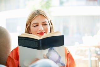 Smiling woman reading a book.