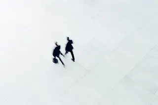 Overhead view of two businessman walking on large empty office.