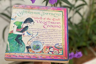 Madhur Jaffrey’s World of the East Vegetarian Cookbook book cover is pictured, with an Asian-inspired font and illustration