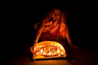 Woman lighting candles for Diwali.