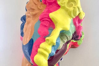 Photograph by the female author featuring a rainbow-ish colored sculpture of the infamous head of “David I” by artist Olivia Bonilla, as seen at Charleston South Carolina’s Art Hotel: The Vendue