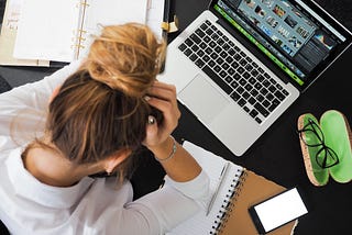 Woman distressed looking over laptop.