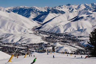 An aerial view of Sun Valley’s Bald Mountain, including snow-covered peaks, skiers, and the ski lift.