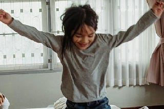 Picture of girl jumping on the bed.