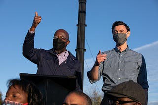 Democratic U.S. Senate candidates Jon Ossoff and Raphael Warnock wearing face masks.
