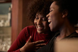 Two friends laugh together.
