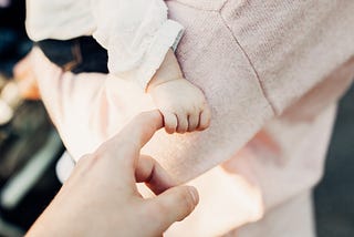 Mother holding baby’s hand