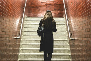 A solitary woman entering a train station.