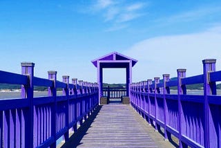 A part of the long bridge with purple wooden sides.