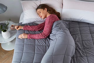 Peacefully sleeping woman tightly wrapped in a weighted blanket
