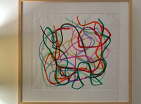 Picture hanging behind a desk featuring curved watercolor lines.