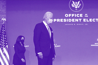 President-elect Joe Biden and Vice President-elect Kamala Harris walk on stage wearing masks.