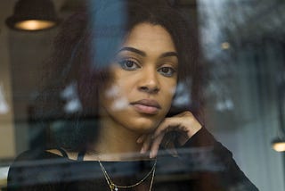 Mixed-race woman looking out a window.