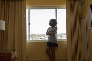 A photo of an unhappy black woman looking out the window.